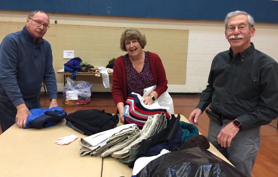 Ithaca Rotary members Ray Brisson, Linda Brisson and Richard Kops work on sorting clothes donated for the club's "Share the Warmth" campaign at Immaculate Conception School in Ithaca.