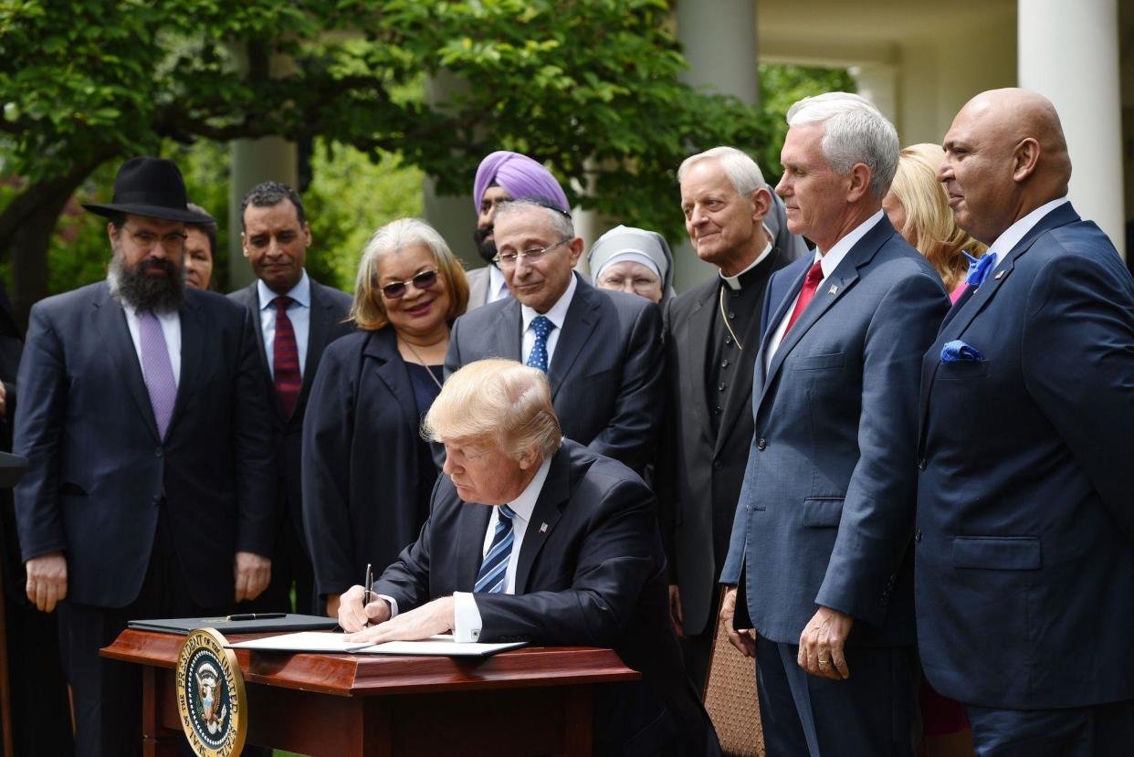 President Donald Trump signs an Executive Order on Promoting Free Speech and Religious Liberty in the Rose Garden of the White House on May 4, 2017: AFP/Getty Images