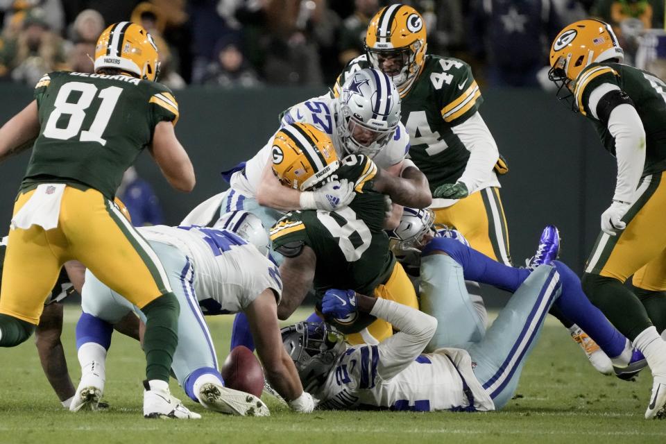 Green Bay Packers wide receiver Amari Rodgers (8) fumbles a punt return as Dallas Cowboys' Luke Gifford (57), and Israel Mukuamu (24), bottom, assist on the tackle during the second half of an NFL football game Sunday, Nov. 13, 2022, in Green Bay, Wis. (AP Photo/Morry Gash)