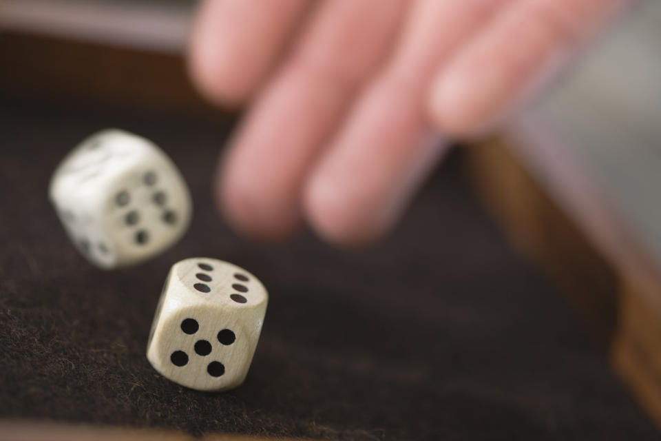 a person's hands throwing dice