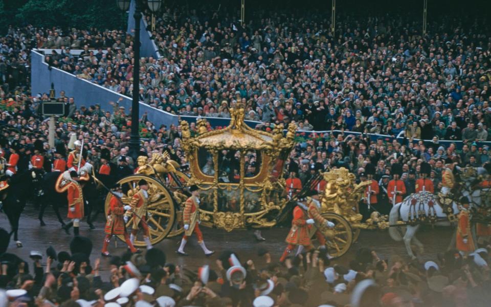 Queen Elizabeth II rides in the Gold State Coach past crowds of spectators near Admiralty Arch and Trafalgar Square during her Coronation procession - Popperfoto