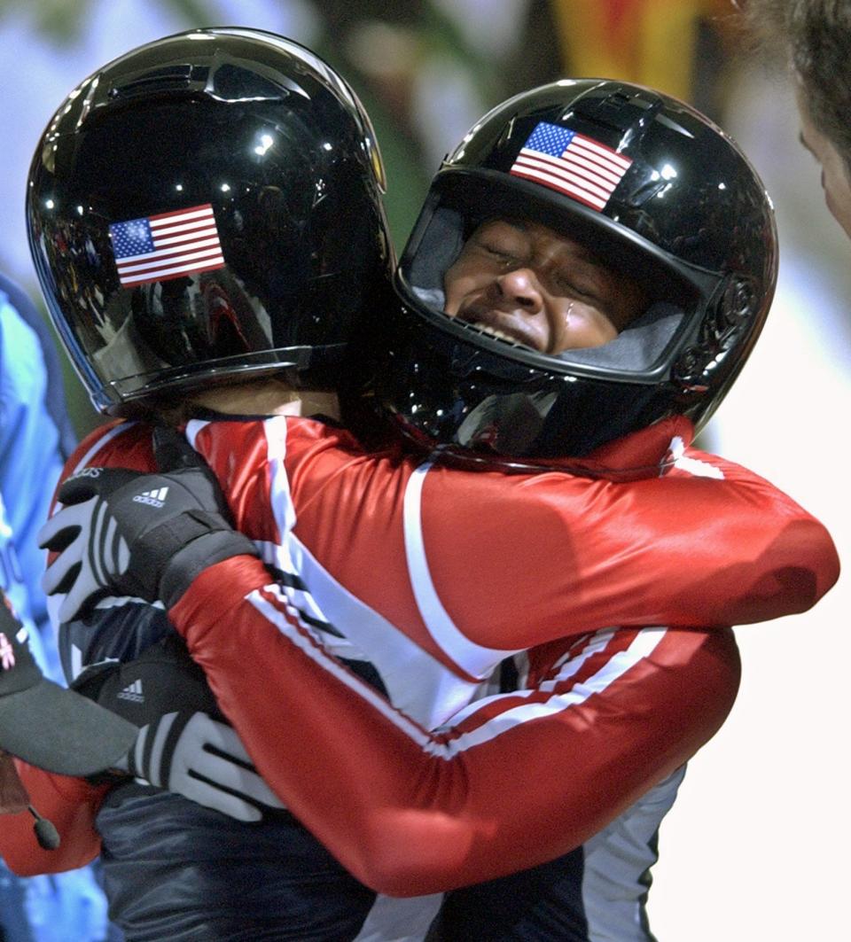 Vonetta Flowers, right, cries as she hugs her teammate Jill Bakken of the United States after their final and gold medal winning run in the Two Woman Bobsled inaugural event at Salt Lake City Winter Olympics in Park City, Utah, Tuesday, Feb. 19, 2002. Flowers, 28, is the first black athlete to win a medal at any Winter Games. 