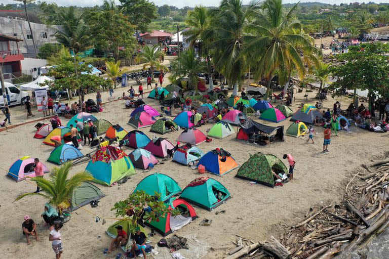 Migrantes venezolanos acampan con la esperanza de subir a un barco en el puerto colombiano de Necoclí