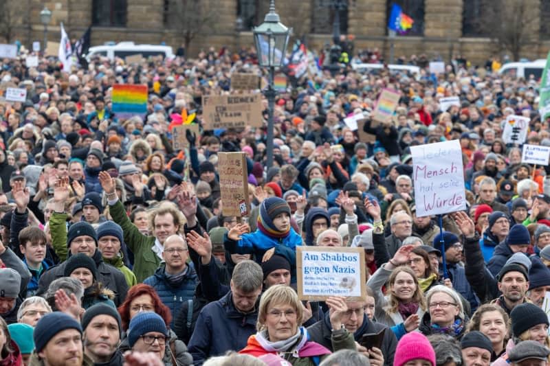 People take part in a demonstration of the Dresden action alliance "Wir sind die Brandmauer Dresden" on the theater square of the Saxon state capital against right-wing extremist activities. Daniel Schäfer/dpa