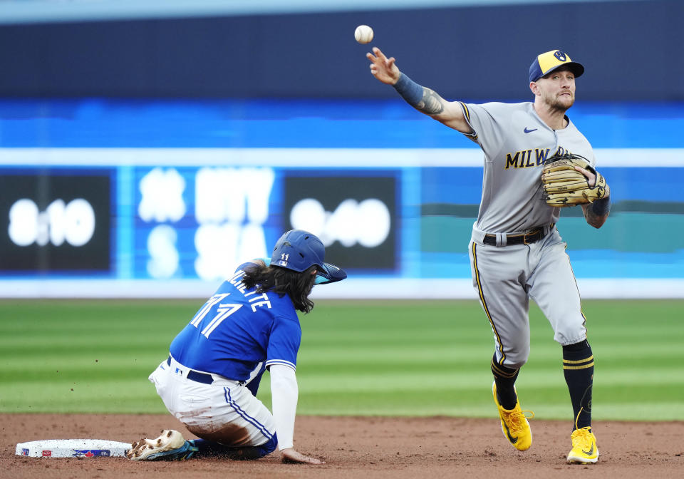 Milwaukee Brewers shortstop Brice Turang throws to first after forcing out Toronto Blue Jays' Bo Bichette (11) at second base, on a double play hit into by Vladimir Guerrero Jr. during the first inning of a baseball game Wednesday, May 31, 2023, in Toronto. (Frank Gunn/The Canadian Press via AP)