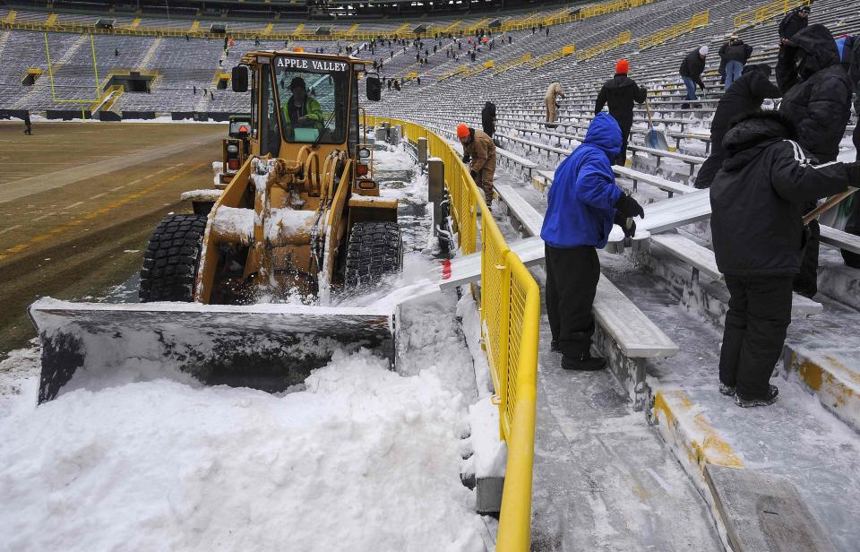 A tractor collects snow which was cleared from the bleachers by paid volunteers at Lambeau Field in Green Bay, Wisconsin, the home field of the Green Bay Packers of the National Football League (NFL), December 21, 2013. In winter months, the team calls on the help of hundreds of citizens, who also get paid a $10 per-hour wage, to shovel snow and ice from the seating area ahead of games, local media reported. The Packers will host the Pittsburgh Steelers on Sunday, December 22. REUTERS/Mark Kauzlarich (UNITED STATES - Tags: ENVIRONMENT SPORT FOOTBALL)