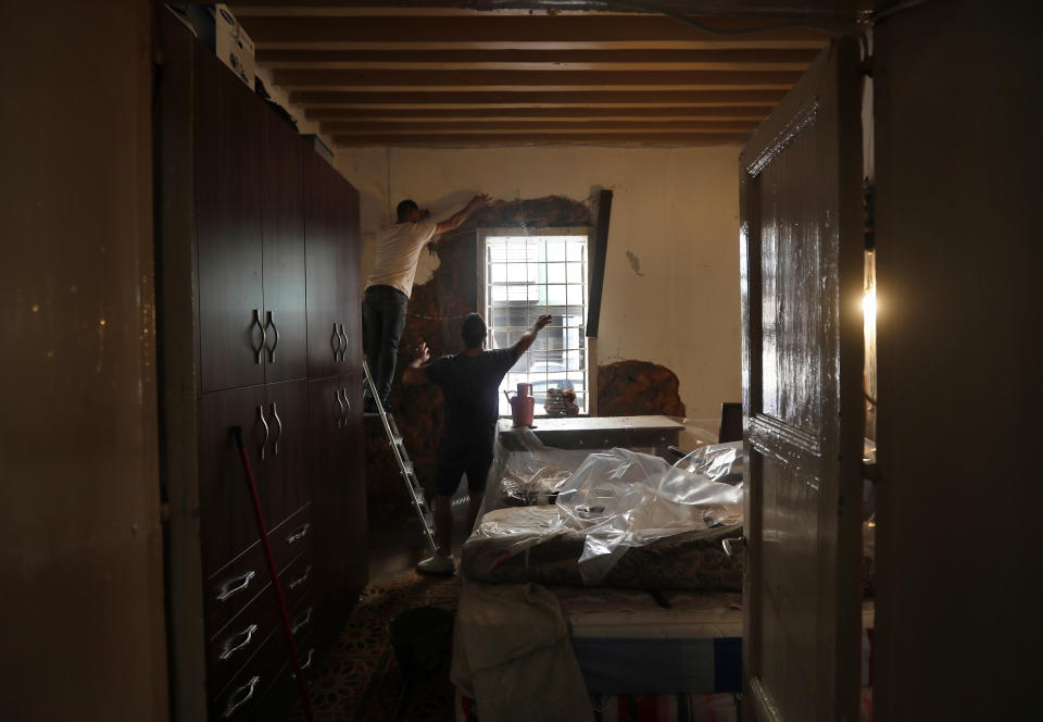 Workers reconstruct a wall of a heritage house that was damaged by Aug. 4 explosion that hit the seaport of Beirut, in Lebanon, Tuesday Aug. 25, 2020. In the streets of Beirut historic neighborhoods, workers are erecting scaffolding to support buildings that have stood for more than a century - now at risk of collapse after the massive Aug. 4 explosion that tore through the capital. (AP Photo/Hussein Malla)