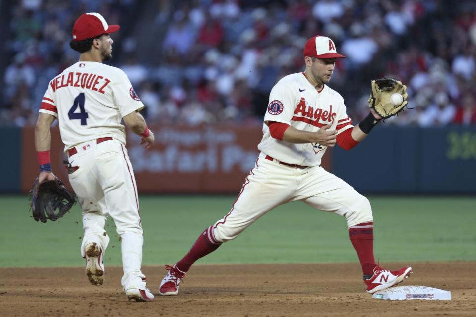 Angels second baseman David Fletcher, right, takes a toss from shortstop Andrew Velazquez en route to turning a double play.