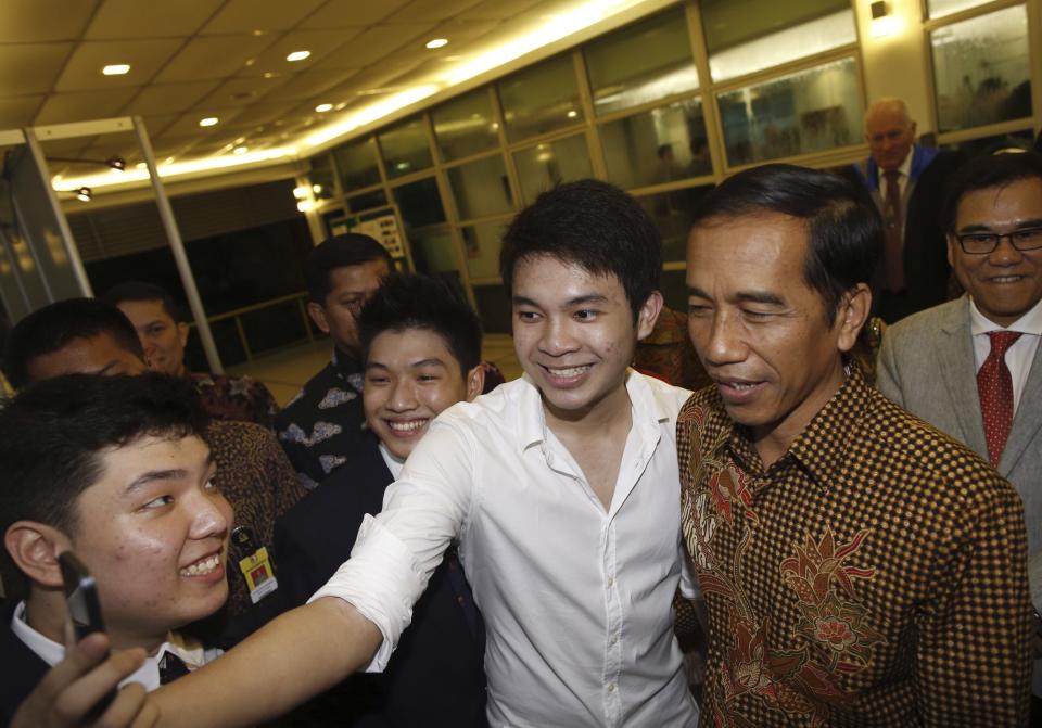 A student takes a selfie with Indonesian President Widodo as he arrives for his son's graduation ceremony at ACS International in Singapore