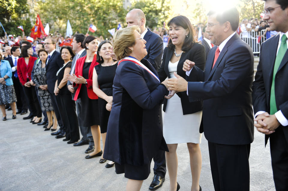 Chile's new President Michelle Bachelet, center, is welcomed by her ministers and other administration officials as she arrives to La Moneda presidential palace in Santiago, Chile, Tuesday, March 11, 2014. Bachelet, who led Chile from 2006-2010, was sworn-in as president on Tuesday. (AP Photo/Victor Ruiz Caballero)