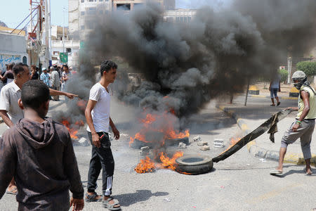 Protesters block a street with burning tires after the Yemeni Riyal has severely plunged against foreign currencies, in Aden, Yemen September 2, 2018. REUTERS/Fawaz Salman