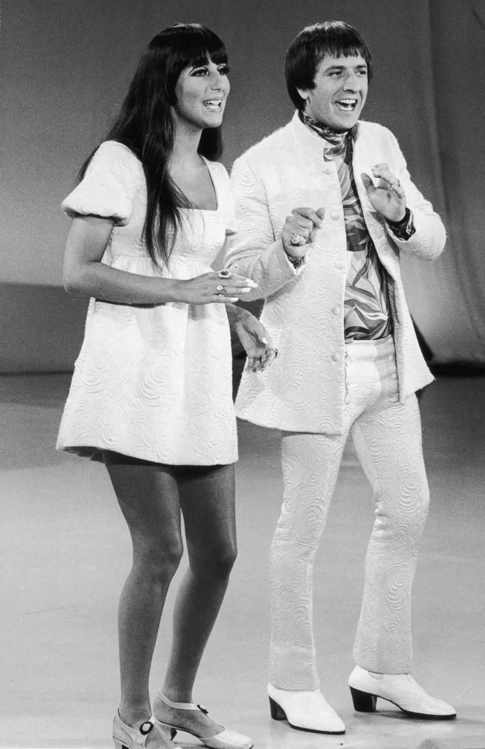 circa 1965:  Full-length image of married American singers Cher (left) and Sonny Bono (1935 - 1998) of the pop duo Sonny and Cher performing on 'The Carol Burnett Show'. Sonny and Cher are wearing costumes with matching print.  (Photo by Hulton Archive/Getty Images)