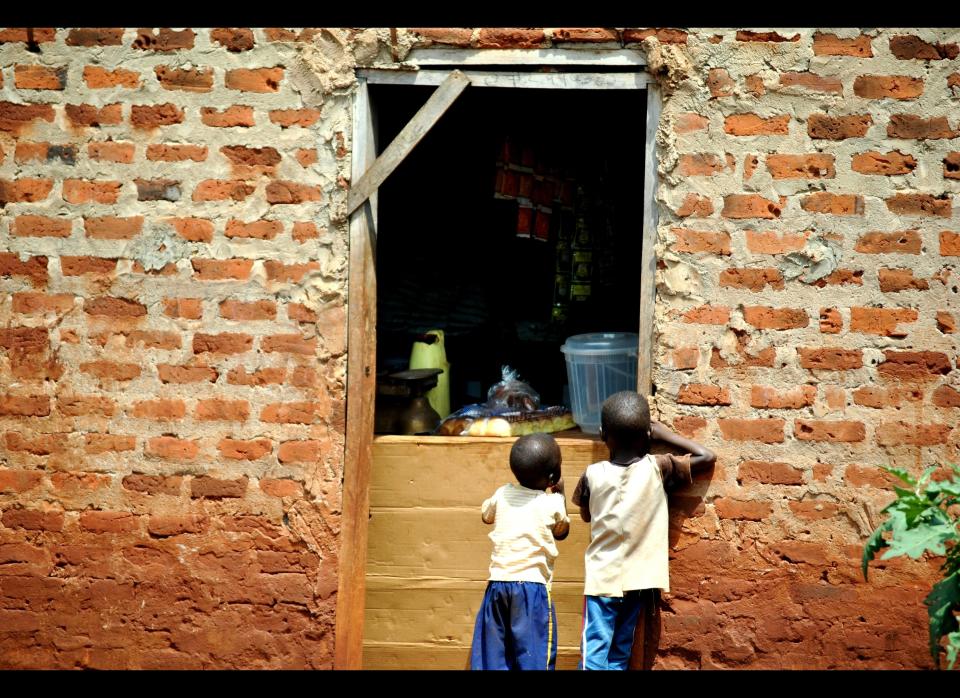 Children line up at the village "shop" in Luwero district,  in Central Uganda. The area suffers a great burden of poverty and has one of the highest rates of orphaned children that make up of the 16% of the population, most of which are left fending for themselves. Others live with their grandparents in poverty stricken homes where they lack basic commodities such as food, clothing and bedding. The district records many cases of child abuse, child sacrifices, defilement, and torture.