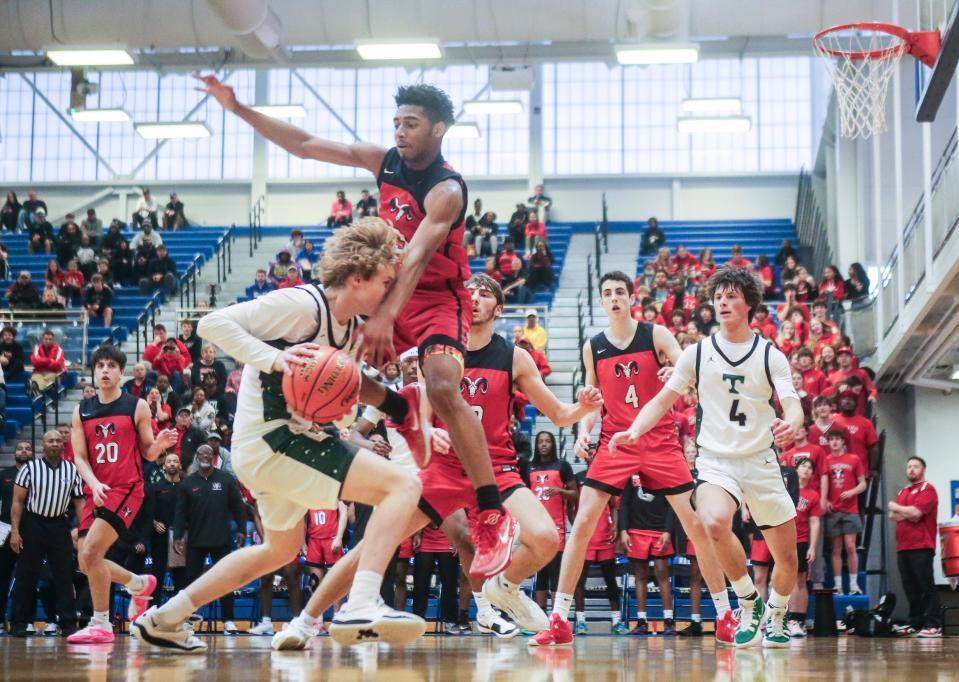 Manual's Malachi Coleman tries to stop Trinity's Avery Frasher on Friday. Coleman led the Crimsons with 11 points.