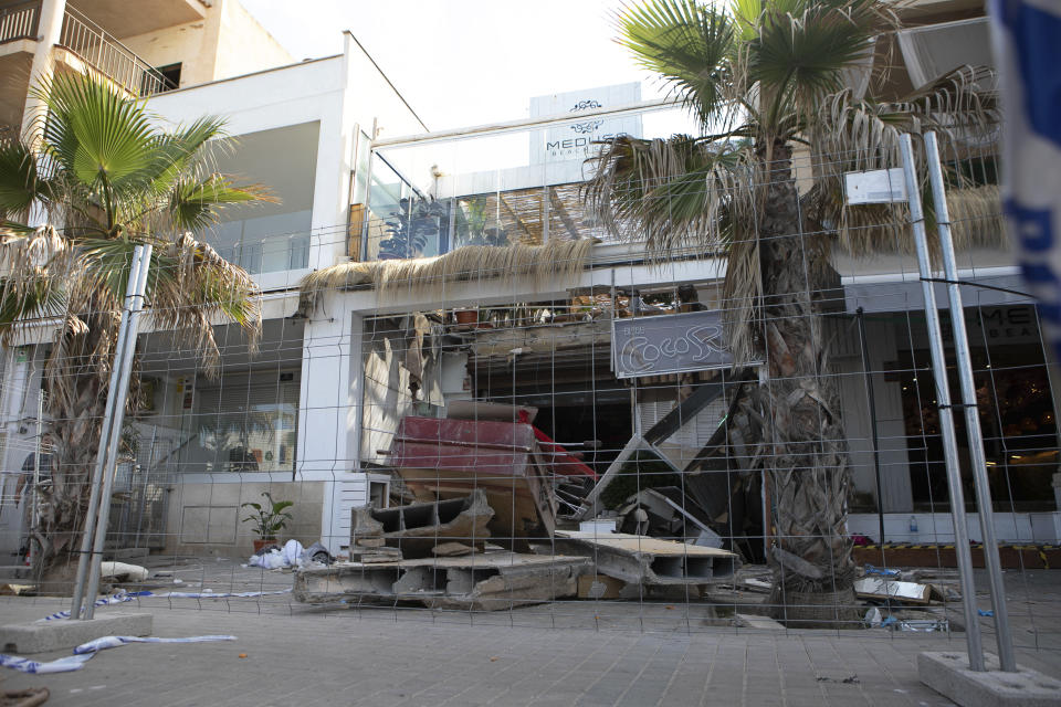 En la imagen, los restos del derrumbe de un edificio en el que fallecieron cuatro personas, vallados para impedir el paso, en Palma de Mallorca, España, el 24 de mayo de 2024. (AP Foto/Francisco Ubilla)