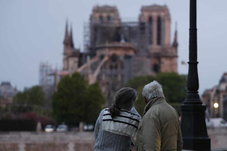 <p>Una pareja observa cómo los bomberos se afanan en apagar las llamas en Notre Dame.<br>Foto: ZAKARIA ABDELKAFI/AFP/Getty Images </p>