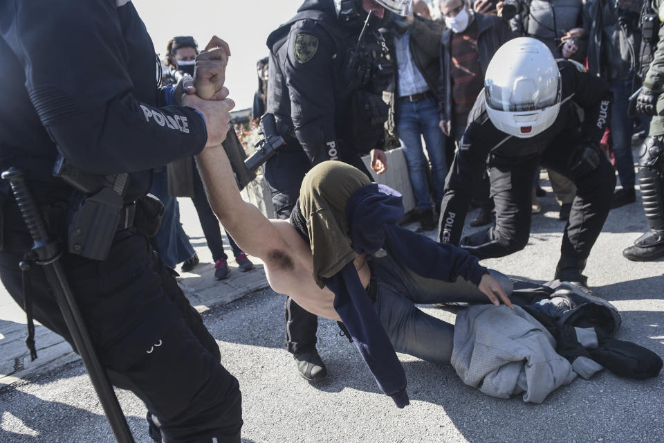 Police detain a protester at the University of Thessaloniki in northern Greece, on Monday, Feb. 22, 2021. Police clashed with protesters and detained more than 30 people in Greece's second-largest city Monday during a demonstration against a new campus security law. (AP Photo/Giannis Papanikos)