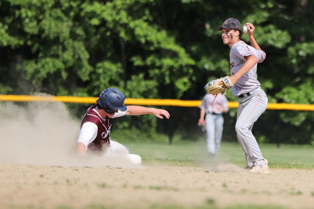 Carver's Teagan Zakrzewski slides in safely as Avon's Jordan Medeiros tries to turn a double play during a game in the Div. 5 preliminary round at Carver High School on Friday, June 2, 2023.