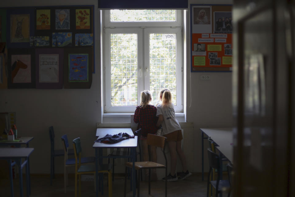 Ukrainian refugee children look outside the window at the Lauder Morasha Jewish school in Warsaw, Poland, Thursday, July 28, 2022. A special summer camp run by Jewish organizations has brought Jewish volunteers from the former Soviet Union to Warsaw to help Ukrainian children. The camp, which ran for most of July and ended Friday, was organized to bring some joy to traumatized children, help prepare them for the school year ahead in Polish schools and give their mothers some time to themselves. (AP Photo/Michal Dyjuk)