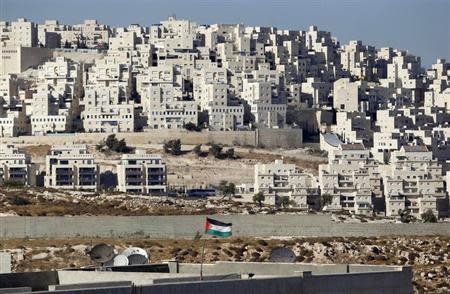 A Palestinian flag flutters in front of a Jewish settlement near Jerusalem known to Israelis as Har Homa and to Palestinians as Jabal Abu Ghneim August 24, 2010. REUTERS/Ammar Awad