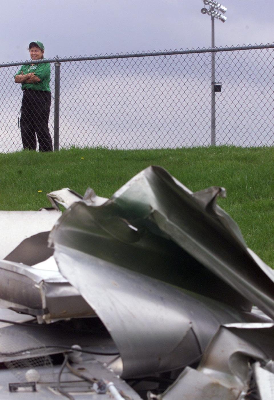 -

-Text: By Michael Heinz/Journal and Courier--Linda Barnett, athletic director at Clinton Central High School, looks at the scoreboard that a confirmed tornado on Tuesday blew from one end of the stadium to the other end Wednesday, April 21, 2004 at the school near Michigantown. Barnett cancelled three athletic events at the sports complex a couple of hours before the storm hit.