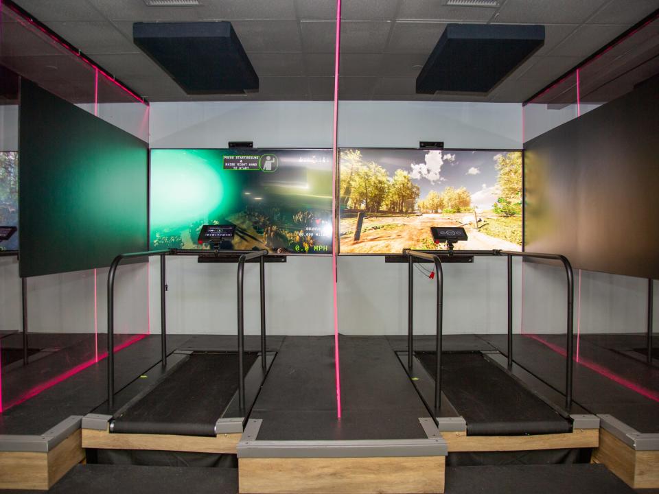 Treadmills in front of a screens at Roam149