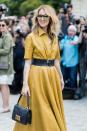 <p>Dion wears a yellow leather A-line dress with a black leather belt, Dior bag, and aviator sunglasses. (Photo: Getty) </p>