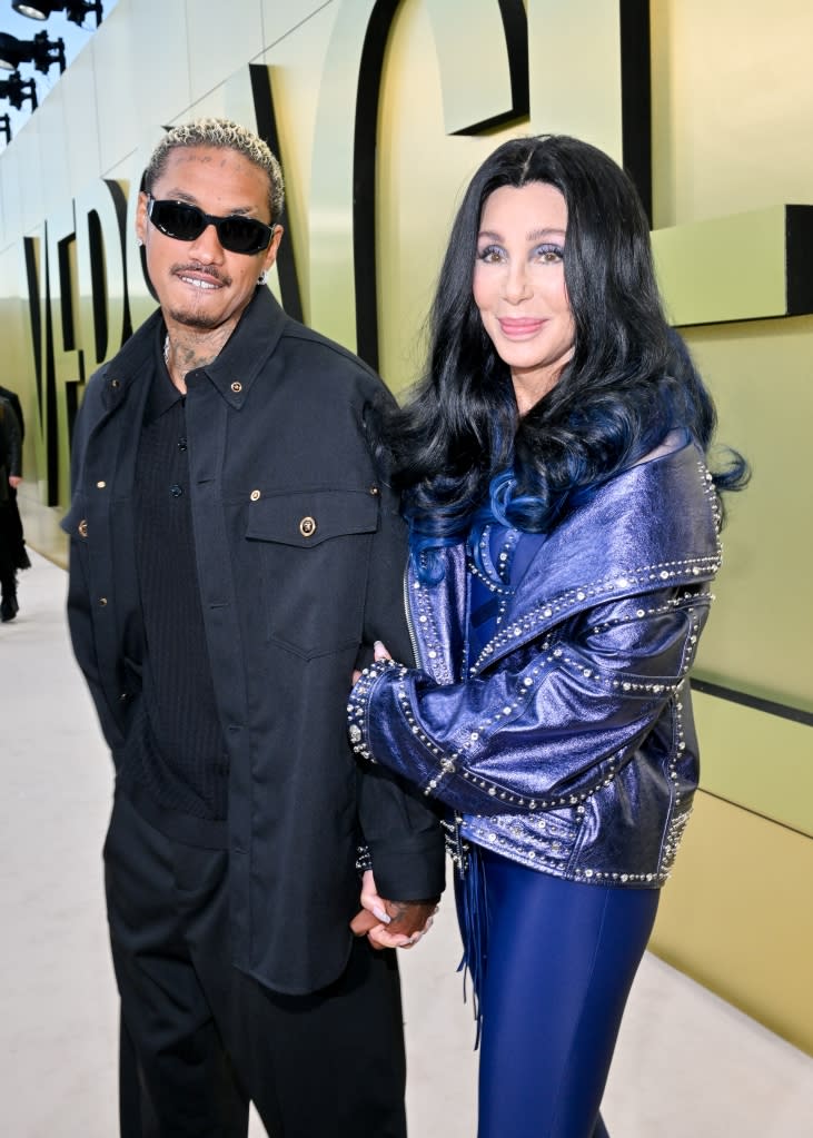 Alexander “A.E.” Edwards and Cher at the Versace Fall-Winter 2023 Fashion Show held at Pacific Design Center on March 9, 2023 in West Hollywood, California.