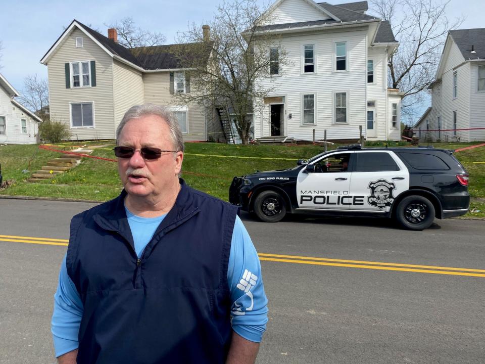 Bob Ball, a Richland County coroner's investigator, talks Tuesday outside the vacant house at in the 200 block of West Third Street where human remains were found in a crawl space in the attic.