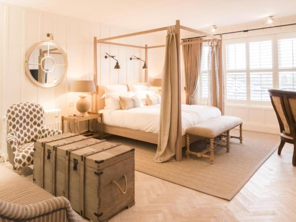 Las camas con dosel y los detalles de madera en bruto crean un ambiente acogedor en Sandy Mount Beach House (Sandy Mount House)