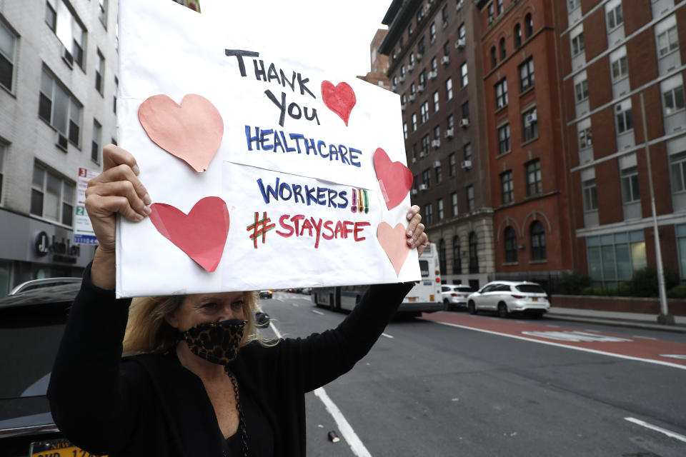 People hold signs and cheer to show their gratitude to medical staff and frontline workers in New York City. (John Lamparski/Getty Images)