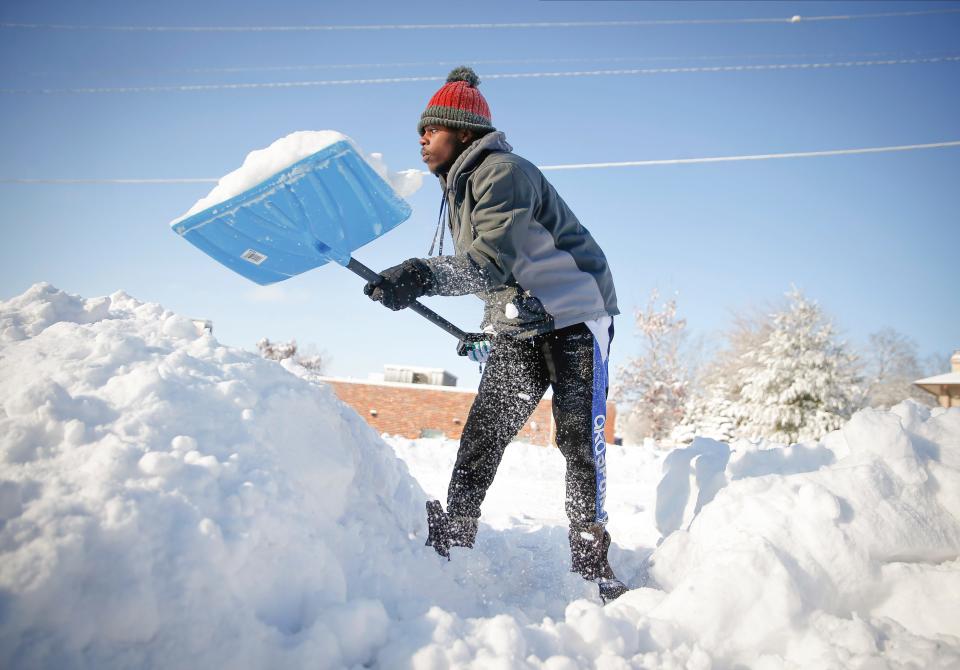 Bonny Obutu shovels snow off his sidewalk in West Des Moines, Iowa, on Saturday, Jan. 15, 2022, after a winter storm dumped several inches of snow across central Iowa.