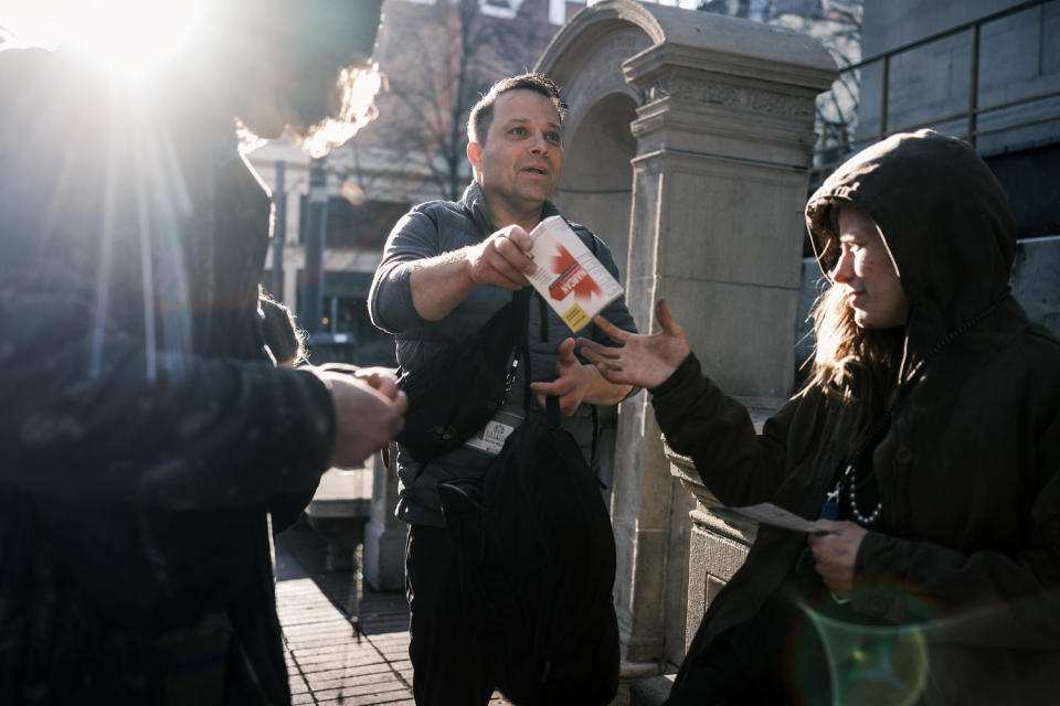 Ricco Mejia passes out Narcan to a group of people in downtown Portland (Jordan Gale for NBC News)