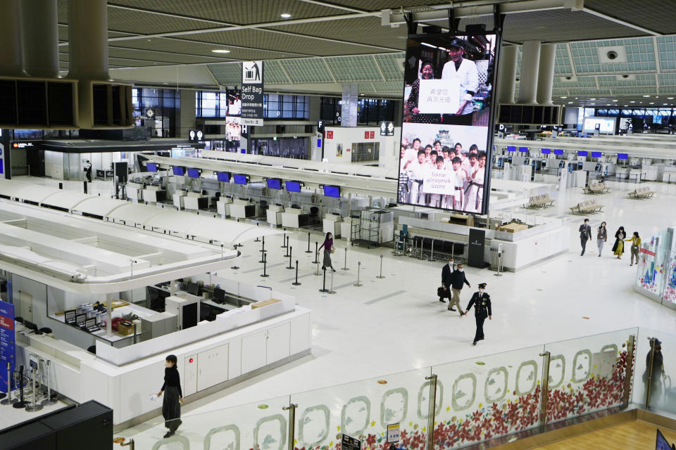 FILE - Passengers walk through the ticketing counter floor for international flights at the Narita International Airport in Narita, east of Tokyo, on Dec. 2, 2021. Hundreds of thousands of foreigners have been denied entry to study, work or visit families in Japan, which has kept its doors closed to most overseas visitors during the pandemic. (AP Photo/Hiro Komae, File)