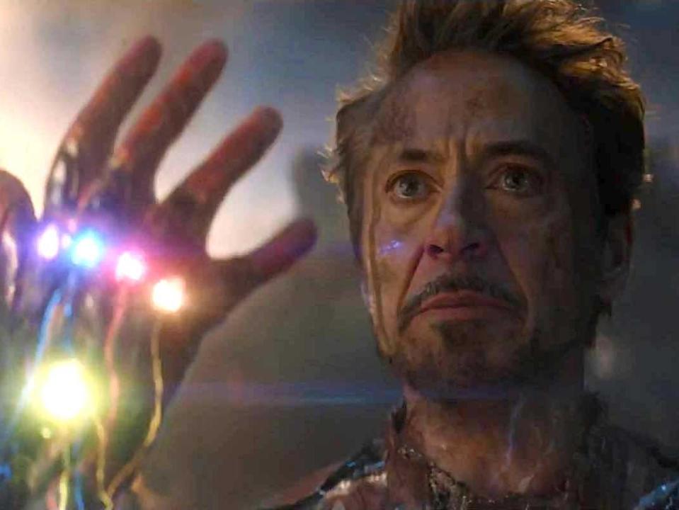 Robert Downey Jr. as Iron Man, holding up a gauntlet with six stones, in "Avengers: Endgame."