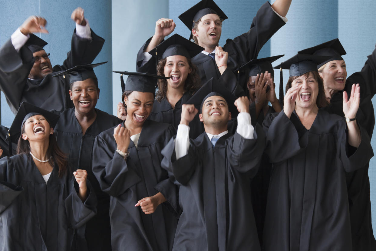 College graduates cheering in caps and gowns