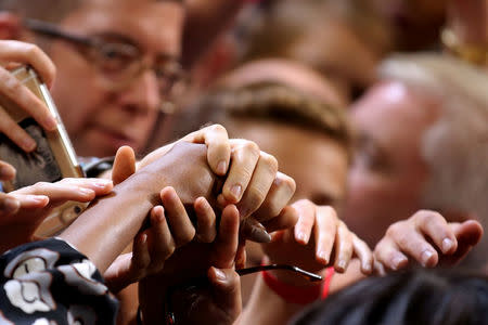 Supporters touch Michelle Obama hand after she delivers a speech during a campaign rally in support of Hillary Clinton in Winston-Salem, North Carolina. REUTERS/Carlos Barria