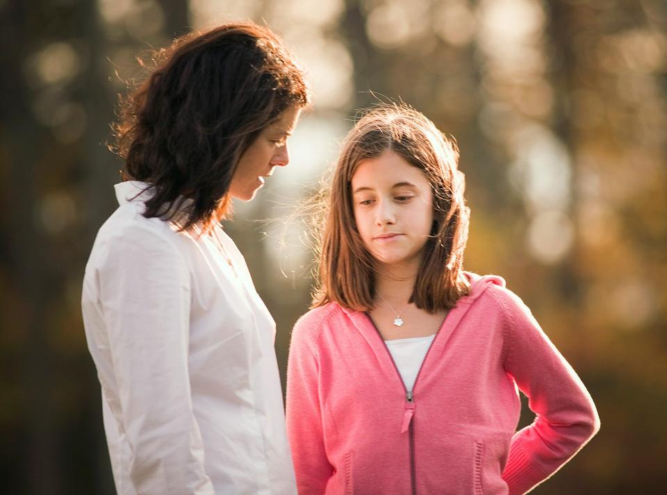 Mother and daughter talking outdoors