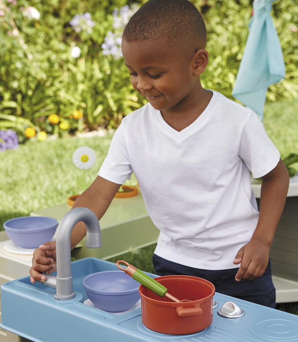 Child playing with backyard bungalow sink