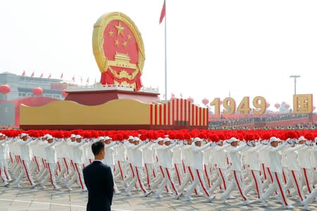 Performers travel past Tiananmen Square with a float featuring the Chinese national emblem during the parade marking the 70th founding anniversary of People's Republic of China