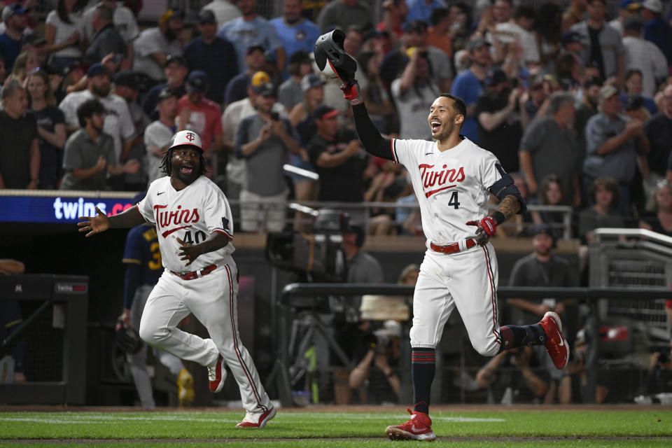 Minnesota Twins' Carlos Correa (4) celebrates as he runs to home plate with third base coach Tommy Watkins (40) after hitting a walk off two-run home run against the Milwaukee Brewers during the ninth inning of a baseball game, Tuesday, June 13, 2023, in Minneapolis. Twins won 7-5. (AP Photo/Craig Lassig)