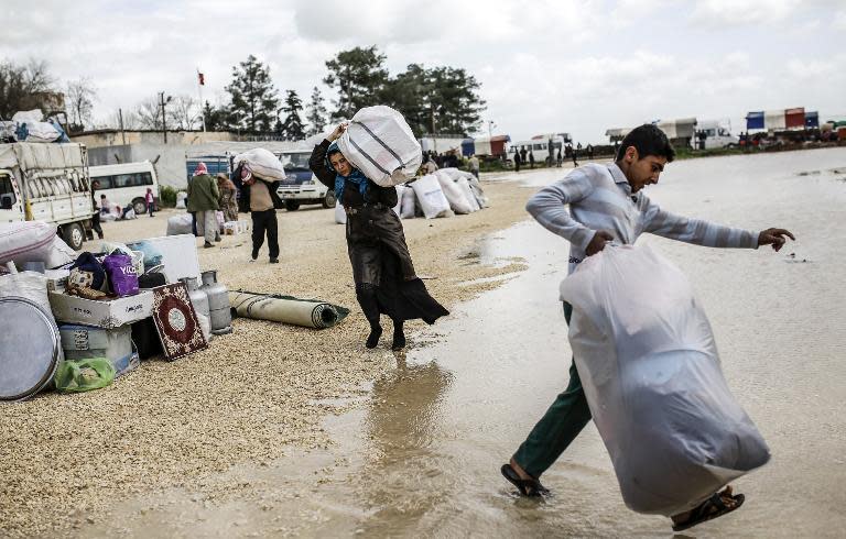 Syrian Kurdish people return to the Syrian town of Kobane, also known as Ain al-Arab, on March 30, 2015