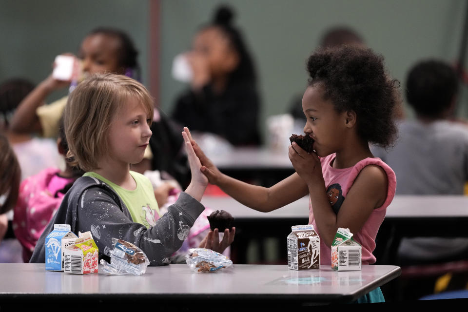Third grader Katherine Nelson, left, and Shawn Kennedy, kindergarten, talk during breakfast at Williams Science and Arts Magnet school Friday, May 10, 2024, in Topeka, Kan. The school is just a block from the former Monroe school which was at the center of the Brown v. Board of Education Supreme Court ruling ending segregation in public schools 70 years ago. (AP Photo/Charlie Riedel)