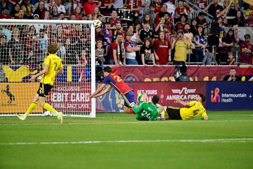 Real Salt Lake midfielder Matt Crooks and Crew goalkeeper Evan Bush collide on Saturday.