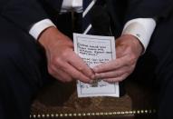 U.S. President Donald Trump holds his prepared questions as he hosts a listening session with high school students and teachers to discuss school safety at the White House in Washington, U.S., February 21, 2018. REUTERS/Jonathan Ernst