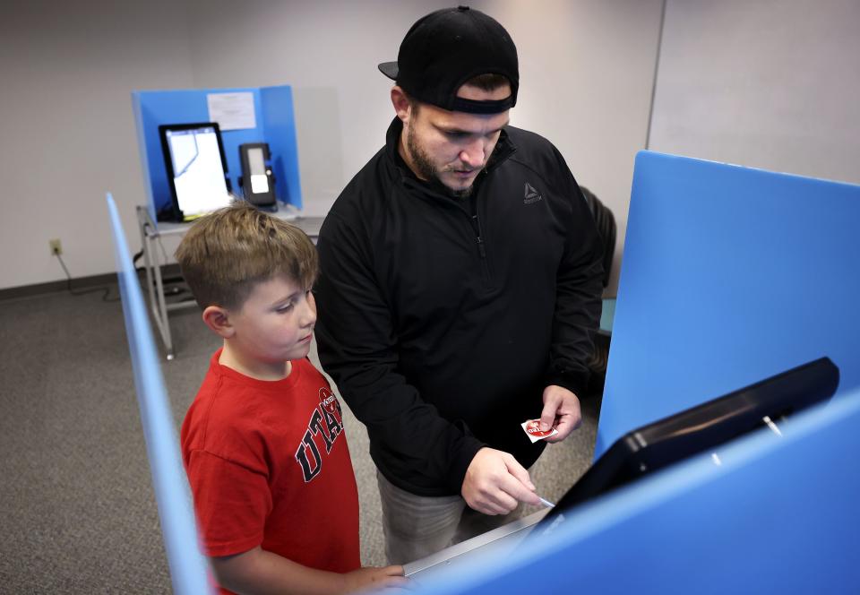 Cooper Brannon, 8, watches his father, Austin, vote at the Salt Lake County Government Center in Salt Lake City on Wednesday, Nov. 21, 2023. | Laura Seitz, Deseret News