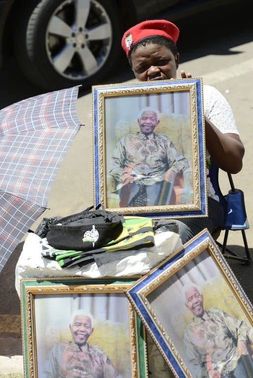 A street vendor sells portraits of former South African president Nelson Mandela outside the 53rd National Conference of the African National Congress (ANC) on December 19, 2012 in Bloemfontein. Mandela will spend Christmas Day in hospital, the South African government said Monday