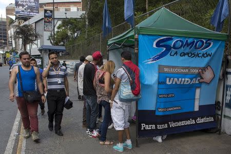 People pass by a tent for MIN Unidad Party in a main avenue in Caracas, November 3, 2015. REUTERS/Marco Bello