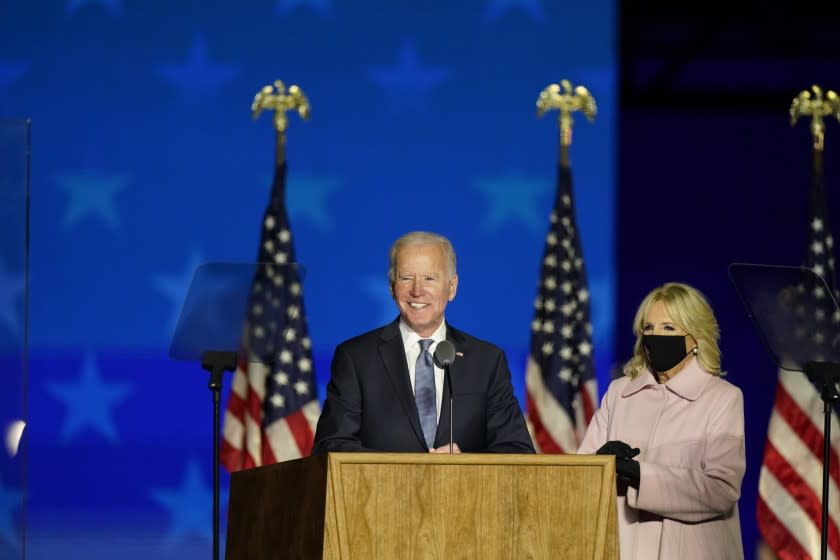 Joe Biden speaks to supporters Wednesday, Nov. 4, 2020, in Wilmington, Del., as he stands next to his wife Jill Biden.