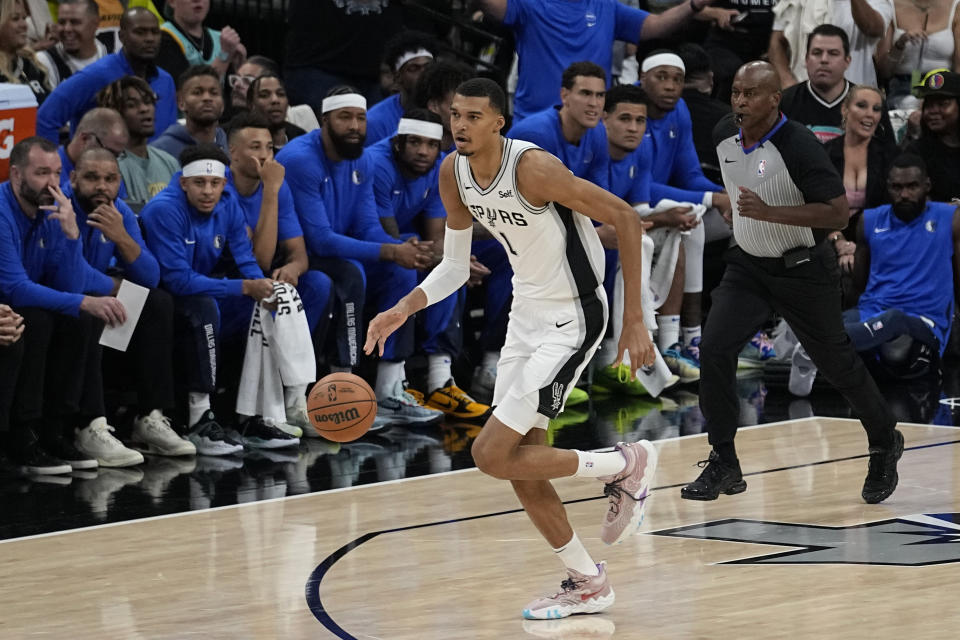 San Antonio Spurs center Victor Wembanyama brings the ball up against the Dallas Mavericks during the first half of an NBA basketball game in San Antonio, Wednesday, Oct. 25, 2023. (AP Photo/Eric Gay)